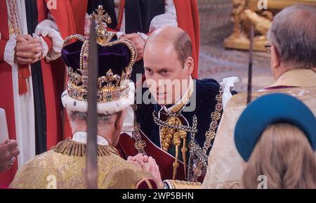 König Karl III. Krönungshuldigung 6. Mai 2023 mit Prinz William, Prinz von Wales, Herzog von Cambridge, kniet vor seinem Vater König Karl III. Nieder und legt seine Hände zwischen die Hände des Königs und sagt: "ich, William, Prinz von Wales, schwöre dir meine Treue und glaube und Wahrheit, die ich dir als dein Herrscher des Lebens und des Leibes geben werde. Westminster Abbey Westminster London UK Stockfoto