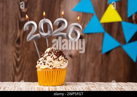 Happy New Year 2026 - hölzerner Hintergrund mit Wimpeln Stockfoto