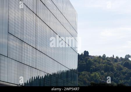 Moderne Gebäudefassade mit innovativem Solarschutzsystem auf einer nach Süden gerichteten Glasfassade. Halbkreisförmiges Gebäude mit welligen Linien von Mol Stockfoto