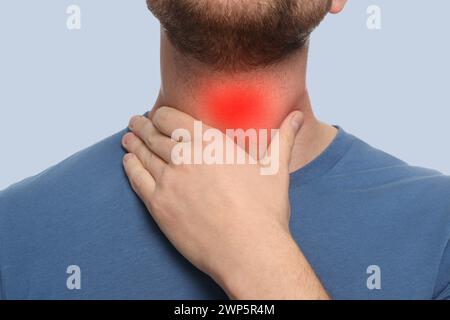 Endokrines System. Mann macht Schilddrüsenselbstuntersuchung auf grauem Hintergrund, Nahaufnahme Stockfoto