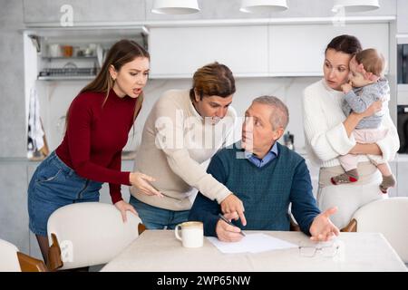 Familie verschiedener Altersgruppen streiten beim Ausfüllen wichtiger Dokumente Stockfoto