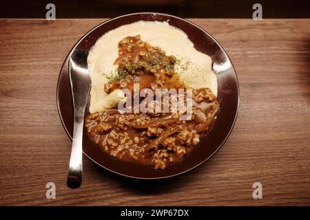 Blick von oben auf Omurice, Omelett und Reis, mit Curry auf der Holztheke. Stockfoto