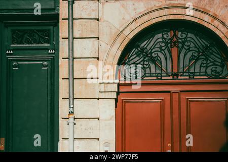 Schöne alte Steinmauer mit grünen und roten Vintage Holztüren. Filmische Filterung von Details zur Altstadtarchitektur. Nostalgische Straßenstimmung. Stockfoto