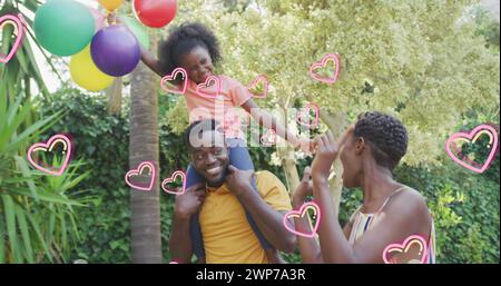 Das Bild der Herzen über die glückliche afroamerikanische Familie im Garten Stockfoto