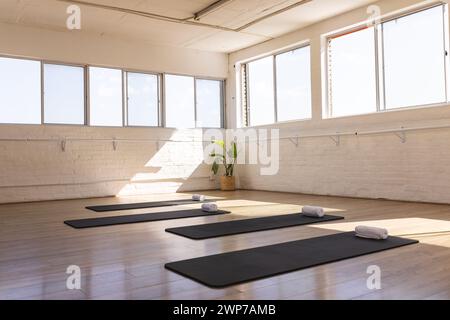 Ein ruhiges Yoga-Studio erwartet die Praktizierenden, in natürlichem Licht mit Kopierraum getaucht Stockfoto