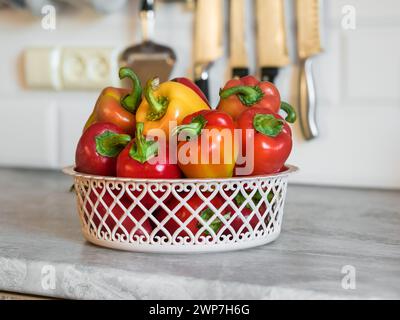 Rote und gelbe Paprika (Paprika, Paprika, Paprika) in einem Korb auf der Küchentheke Stockfoto