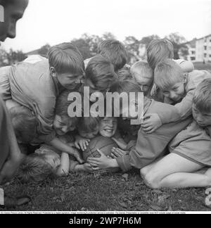 Rugby 1940. Eine Gruppe junger Rugbyspieler, alle auf einem lächelnden Jungen, der sich am Rugbyball festhält. Der Rugbyball hat eine ovale Form, vier Panels und ein Gewicht von etwa 400 Gramm. 1942. Kristoffersson Ref. A57-5 Stockfoto