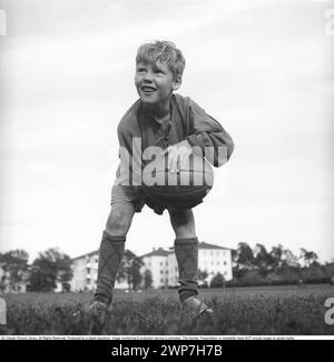 Rugby 1940. Ein junger Rugbyspieler hält den Rugbyball in den Händen. Der Rugbyball hat eine ovale Form, vier Panels und ein Gewicht von etwa 400 Gramm. 1942. Kristoffersson Ref. A57-2 Stockfoto