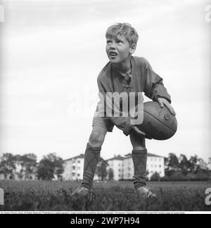 Rugby 1940. Ein junger Rugbyspieler hält den Rugbyball in den Händen. Der Rugbyball hat eine ovale Form, vier Panels und ein Gewicht von etwa 400 Gramm. 1942. Kristoffersson Ref. A57-1 Stockfoto