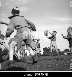 Rugby 1940. Junge Rugbyspieler üben gemeinsam. Der Rugbyball hat eine ovale Form, vier Panels und ein Gewicht von etwa 400 Gramm. 1942. Kristoffersson Ref. A55-2 Stockfoto