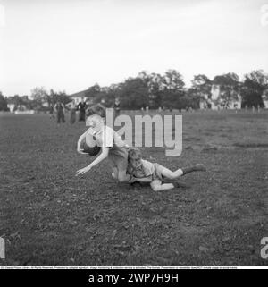 Rugby 1940. Junge Rugbyspieler üben gemeinsam. Der Junge, der mit dem Rugbyball läuft, wird von einem anderen Jungen angegriffen. Der Rugbyball hat eine ovale Form, vier Panels und ein Gewicht von etwa 400 Gramm. 1942. Kristoffersson Ref. A58-6 Stockfoto