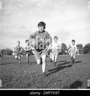 Rugby 1940. Junge Rugbyspieler üben gemeinsam. Der Junge, der mit dem Rugbyball läuft, wird verfolgt. Der Rugbyball hat eine ovale Form, vier Panels und ein Gewicht von etwa 400 Gramm. 1942. Kristoffersson Ref. A56-3 Stockfoto