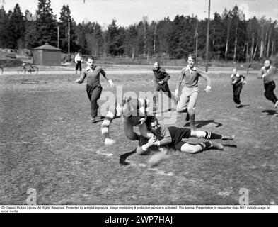 Rugby der 1940er Jahre. Eine Gruppe von Rugbyspielern übt an einem sonnigen Frühlingstag. Der Spieler, der mit dem Rugbyball läuft, wird angegriffen und fällt. Schweden 2. Mai 1940. Kristoffersson Ref. 128-12 Stockfoto