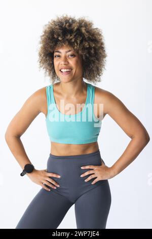 Eine junge birassische Frau posiert selbstbewusst in Fitnesskleidung Stockfoto
