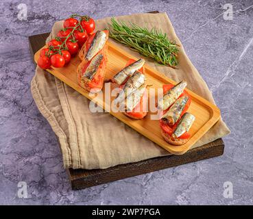 Ein Tablett mit geräucherten Sardinen und Tomaten auf einem Tuch Stockfoto