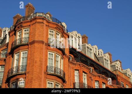 Ein hohes rotes Gebäude mit zahlreichen Fenstern und Balkonen in London Stockfoto