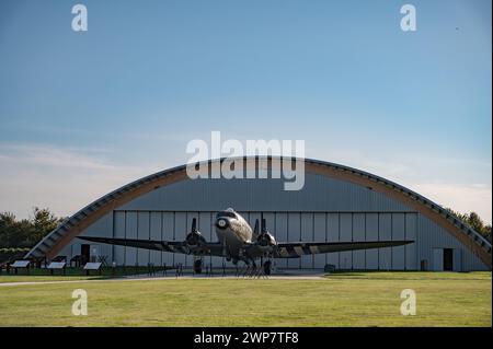 Zweimotorige Douglas C-47 Dakota Skytrain-Flugzeuge aus dem Zweiten Weltkrieg vor dem Hangar im Museum und auf dem Gelände der Merville Battery Stockfoto