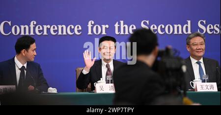 Peking, China. März 2024. Wu Qing (M), Vorsitzender der China Securities Regulatory Commission, sitzt neben Wang Wentao (r), chinesischer Handelsminister, auf einer Pressekonferenz. Die Teilnehmer äußerten sich auf dem Nationalen Volkskongress (NPC) zu wirtschaftlichen und finanziellen Fragen. Quelle: Johannes Neudecker/dpa/Alamy Live News Stockfoto