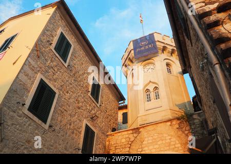 Herceg Novi, Montenegro, 08.10.2022 Sahat Kula, ein Uhrenturm, Durchgang zwischen zwei Plätzen. Es ist eine beliebte Touristenattraktion. Die Flagge von Herceg Stockfoto