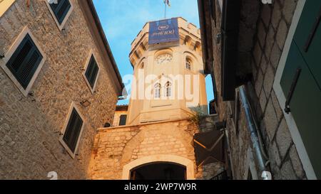 Herceg Novi, Montenegro, 08.10.2022 Sahat Kula, ein Uhrenturm, Durchgang zwischen zwei Plätzen. Es ist eine beliebte Touristenattraktion. Die Flagge von Herceg Stockfoto