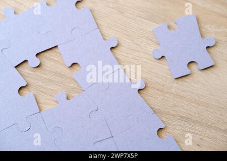 Fragment aus gefaltetem Puzzle aus Pappe und Stapel ungekämmte Puzzleelemente vor Hintergrund, Bildung und Lernen, Gedächtnisverbesserung Stockfoto