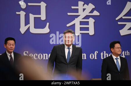 Peking, China. März 2024. Wang Wentao (M), chinesischer Handelsminister, steht auf einer Pressekonferenz zwischen Wu Qing (l), dem Vorsitzenden der chinesischen Wertpapieraufsichtskommission, und Zheng Shanjie, dem Vorsitzenden der staatlichen Entwicklungs- und Reformkommission. Die Teilnehmer erörterten wirtschaftliche und finanzielle Fragen auf dem Nationalen Volkskongress (NPC). Quelle: Johannes Neudecker/dpa/Alamy Live News Stockfoto