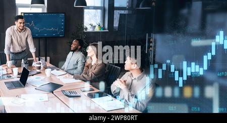 Ein energiegeladener Teamleiter spricht während eines gemeinsamen Meetings seine aufmerksamen Kollegen an Stockfoto