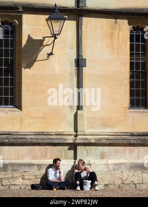 Radcliffe Square liegt im Herzen des historischen Oxford. Hier sehen wir zwei Leute, die an den Wänden der weltberühmten Bodleian Library chillen. Dating bac Stockfoto