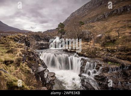 Ein Berggipfel mit einem kleinen Wasserfall inmitten von üppigem Grün Stockfoto