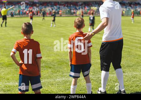 Fussballersatz beim Kinderfußballturnier. Fußballtrainer, der die Schulmannschaft in einem Ligaspiel trainiert Stockfoto