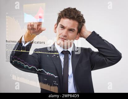 Geschäftsmann, denken und handeln mit Marketing-Hologramm für digitalen Gewinn oder Kosten auf grauem Studiohintergrund. Mann, Händler oder Finanzmakler Stockfoto