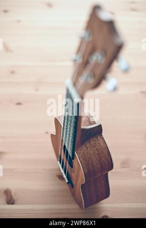 Hochwinkelansicht einer braunen Sopran-Ukulele auf hölzernem Hintergrund Stockfoto