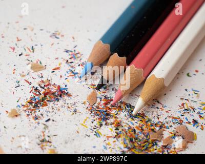 Eine Nahaufnahme von verschiedenen farbigen Bleistiften, die auf einer weißen Tischoberfläche angeordnet sind Stockfoto