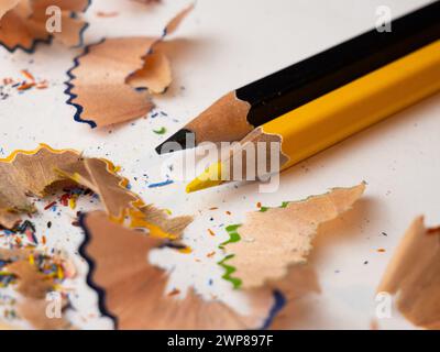 Eine Nahaufnahme von verschiedenen farbigen Bleistiften, die auf einer weißen Tischoberfläche angeordnet sind Stockfoto