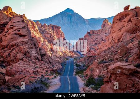 Eine malerische Straße schlängelt sich durch die majestätische orange Landschaft des Valley of Fire Nevada Stockfoto