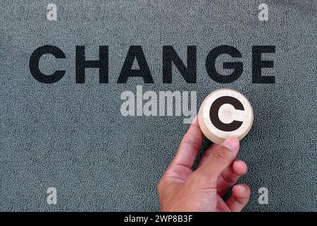 Die männliche Hand hält ein hölzernes C und ändert das Wort Change in Chance Stockfoto