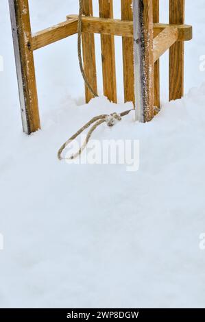 Ein Holzschlitten, der in einer Schneebank steckt Stockfoto