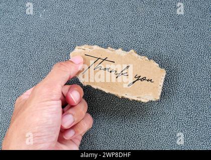 Mann mit zerrissener Pappkarte mit Wort Danke. Stockfoto