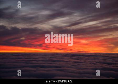 Spektakulärer Sonnenuntergang über einem Wolkenmeer. Wunderschöne Landschaft Stockfoto