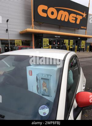 11/12 Eine große Mikrowelle, die von Comet gekauft wurde, wird in ein kleines Auto gequetscht. Nach der Eröffnung des Stores strömen die Käufer zum Comet Store in Derby Stockfoto