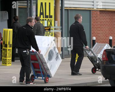 11/12 Comet-Mitarbeiter laden Waschmaschinen in die Autos wartender Kunden. Käufer strömen in den Comet Store in Derby, nachdem der Laden ein Feuer geworfen hat Stockfoto