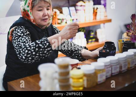Eine Verkäuferin, die Honig und Gewürze auf einem Marktplatz in Doha verkauft Stockfoto