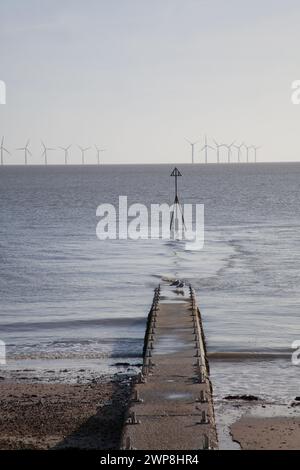 Der Strand von Clacton on Sea in Essex im Vereinigten Königreich mit einer Windfarm auf dem Meer Stockfoto