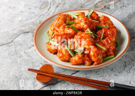 Gobi Mandschurei ist eine beliebte Vorspeise, die aus gebratenem Blumenkohl mit Umami-Chili-Sauce auf dem Teller auf dem Tisch zubereitet wird. Horizontal Stockfoto