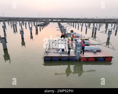 LIANYUNGANG, CHIAN - 6. MÄRZ 2024 - Bauarbeiter arbeiten auf der Baustelle des 940MWFischerei-Solar-Hybridprojekts Photovoltaik-Strom Stockfoto