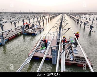 LIANYUNGANG, CHIAN - 6. MÄRZ 2024 - Bauarbeiter arbeiten auf der Baustelle des 940MWFischerei-Solar-Hybridprojekts Photovoltaik-Strom Stockfoto