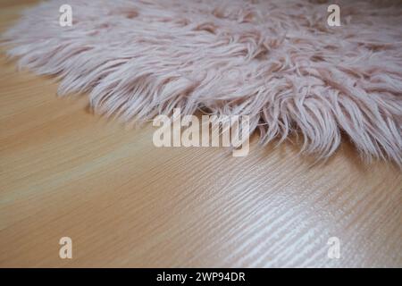 Langer Teppich in Pink auf beigem Laminatboden. Feminine Innenausstattung für ein Zimmer oder Schlafzimmer eines Mädchens oder einer Frau. Inneneinrichtung in rosafarbenen Tönen. Bodenbelag Stockfoto