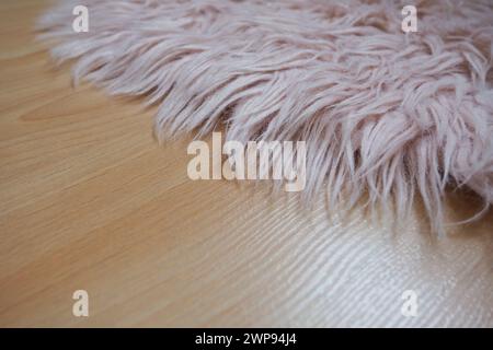 Langer Teppich in Pink auf beigem Laminatboden. Feminine Innenausstattung für ein Zimmer oder Schlafzimmer eines Mädchens oder einer Frau. Inneneinrichtung in rosafarbenen Tönen. Bodenbelag Stockfoto