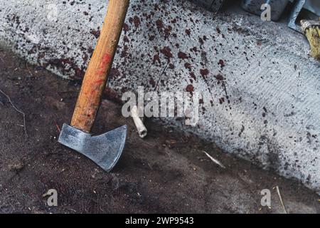 Eine Axt in der Nähe der Wand mit den Bluttropfen, Schlachthof, Schneidenschwein Konzept. Hochwertige Fotos Stockfoto