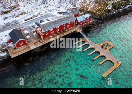Blick aus der Vogelperspektive auf das typische rorbuer-Haus auf der Insel Sakrisøya in der reine-Bucht im Winter, Lofoten-Inseln, Norwegen. Stockfoto